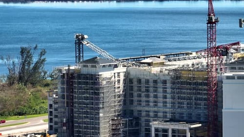 Vista aérea de una grúa de construcción arruinada por el huracán Ian en un alto edificio de apartamentos en el puerto