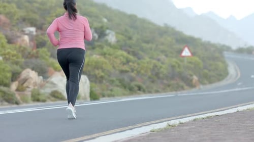 Jogging on mountain road, woman in athletic wear enjoying outdoor exercise, copy space