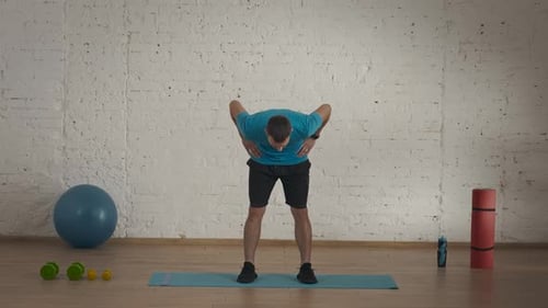 Man Fitness Coach in Sportswear Doing Upper Body Bends Warm Up for Online Class at the Home Studio