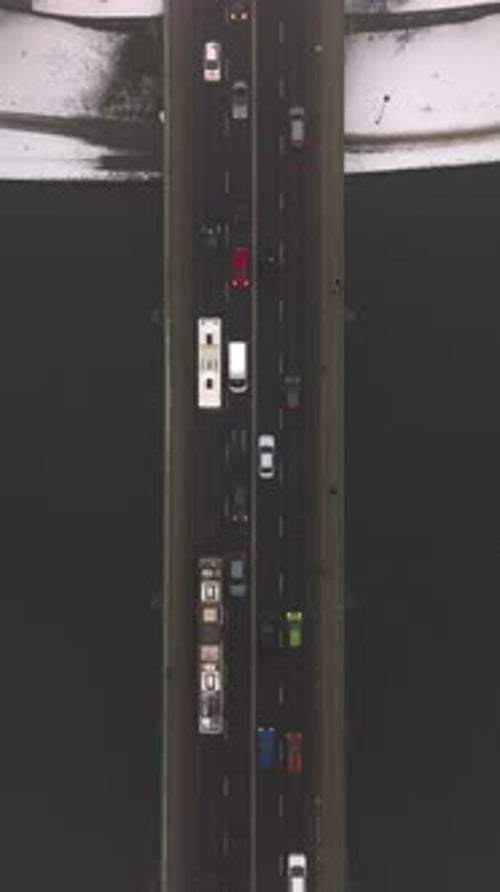 Over a Stream of Cars Driving in Winter Across a Bridge