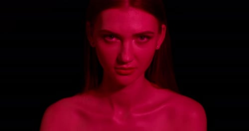 Striking Woman Posing Under Red Studio Light
