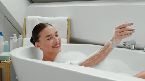 Woman Relaxes in a Tub Full of Bubbles