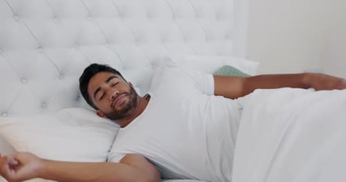 Man Wakes Up and Stretches in Bed