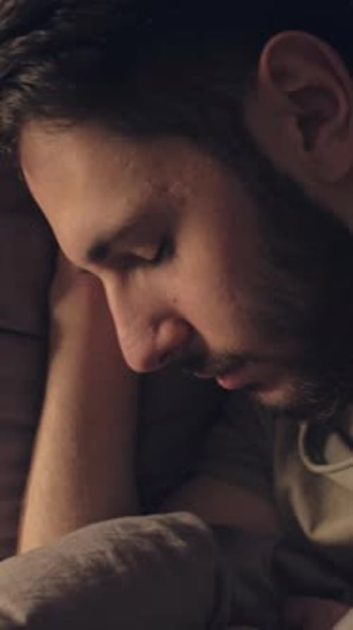 Man Sleeping Peacefully in Bed at Night