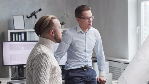 Architect and His Colleague Work in Loft Using Drawing Board Workplace of Young Engineer in Modern