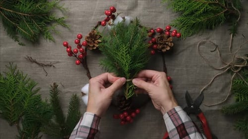 Making Christmas Wreath with Pine and Red Berries