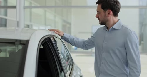Portrait of Handsome Man Touching New Car in Showroom Concept of Car Shopping Buying and Dealership