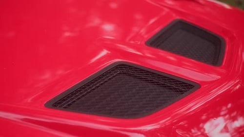 Close View of Air Intake on Hood of Red Sports Car Custom Grille for Blowing Cold Air Into Turbine
