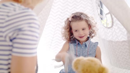 Mother and daughter play inside the teepee