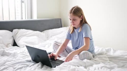 Girl Using Laptop in Bedroom at Home
