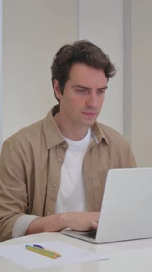 Man Working on Laptop Experiences Back Pain