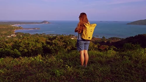Rear View Woman Standing on Hill with Yellow Backpack Looking at Tropical Ocean and Islands, Travele