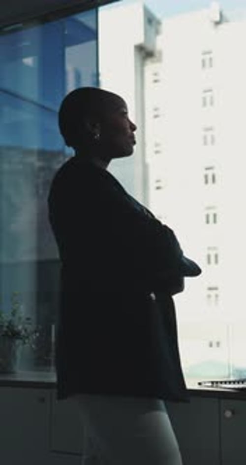 Thinking, woman and arms crossed at window in office for architecture, career ambition
