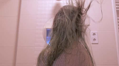 The Hair of the Girl Develops From the Hair Dryer