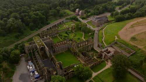Villers Abbey Ruins Nestled Among Trees and Grass Attract Tourists and Staff Who Admire the Beauty