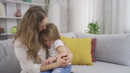 Una chica triste en los brazos de su madre.