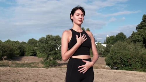 Mujer joven haciendo yoga al aire libre.