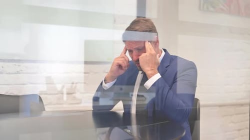 Tired Middle Aged Businessman with Migraine Sitting in Office