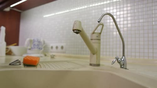 Leaky Faucet Dripping Water in Kitchen Sink