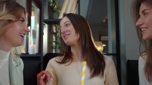 Glückliche junge Freundinnen mit Getränken im Restaurant