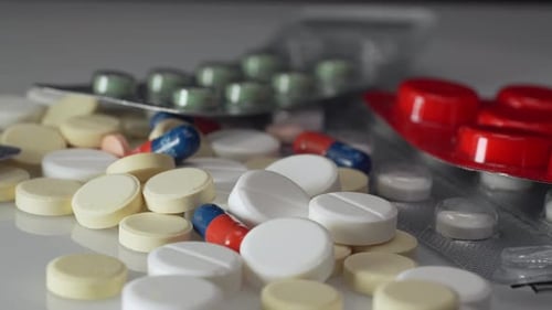 Yellow and white medical pills, red and green capsules rotating in 4K. Pills, drugs, supplements