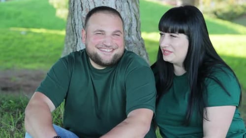 Young Couple Relaxing and Talking in the Park