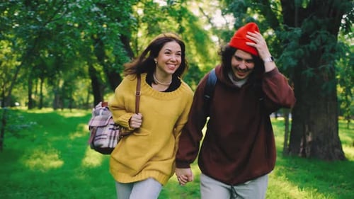 Running Through a Vibrant Park a Happy Couple Holds Hands and Smiles The Greenery and Glowing