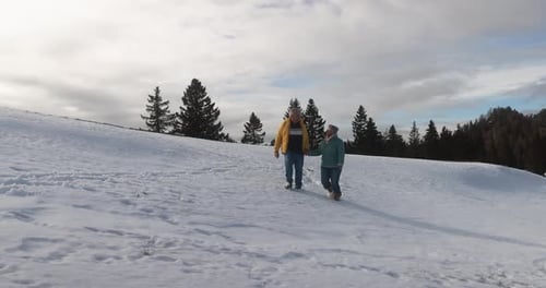 Senior Couple Walks Across Snowy Winter Field