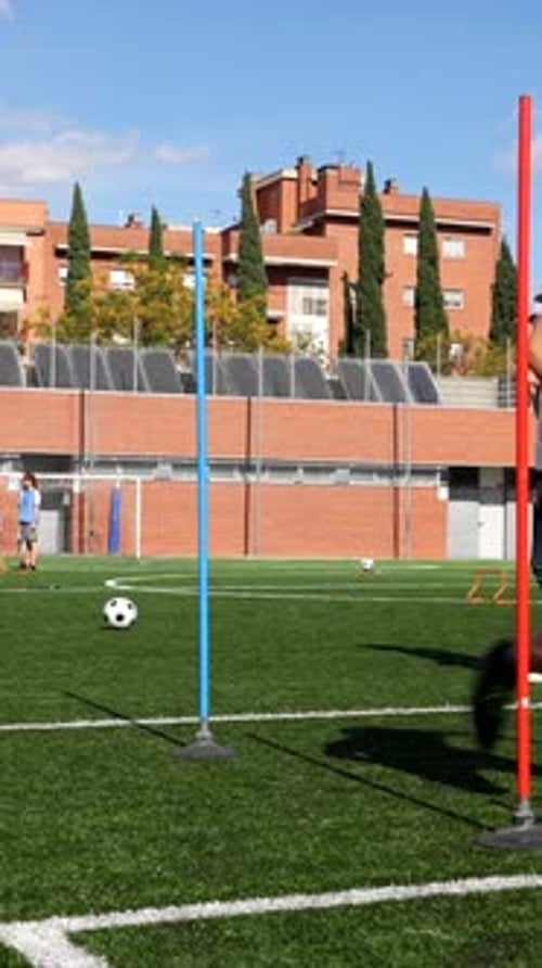 Soccer Players Training Dribbling Skills with a Ball on a Turf Field