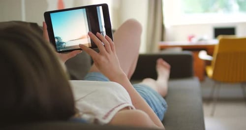 Woman, sofa and scroll on tablet for photography memories of vacation with digital screen