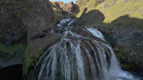 Aerial Shot Of Icelandic Waterfall With Volcanic Glacier On A Sunny Day