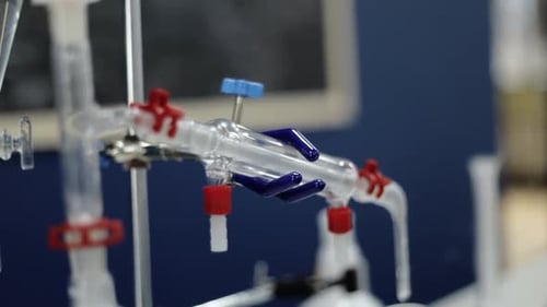 In a slow-motion display, laboratory glass tubes reveal subtle chemical interactions, emphasizing th