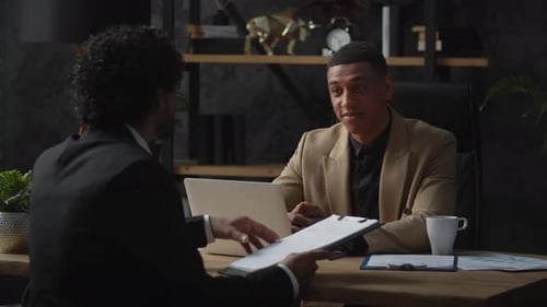 Businessmen Discussing Documents in Modern Office