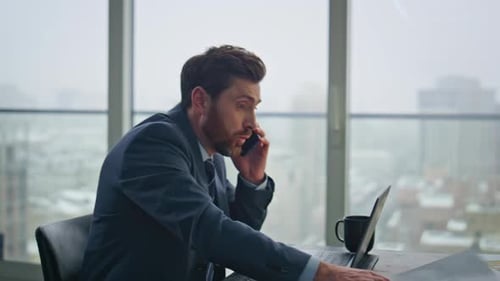 Man in Suit Talking on Phone in Office