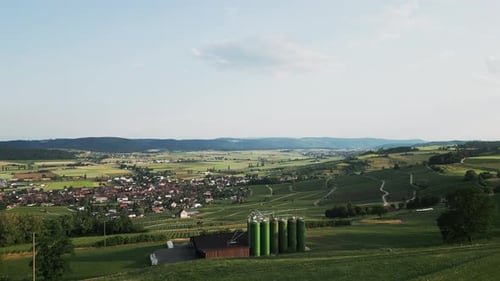 Aerial view of small village surrounded by fields and meadows