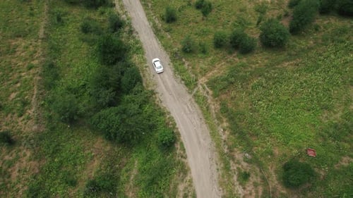 White Car Driving on a Dirt Road in the Countryside