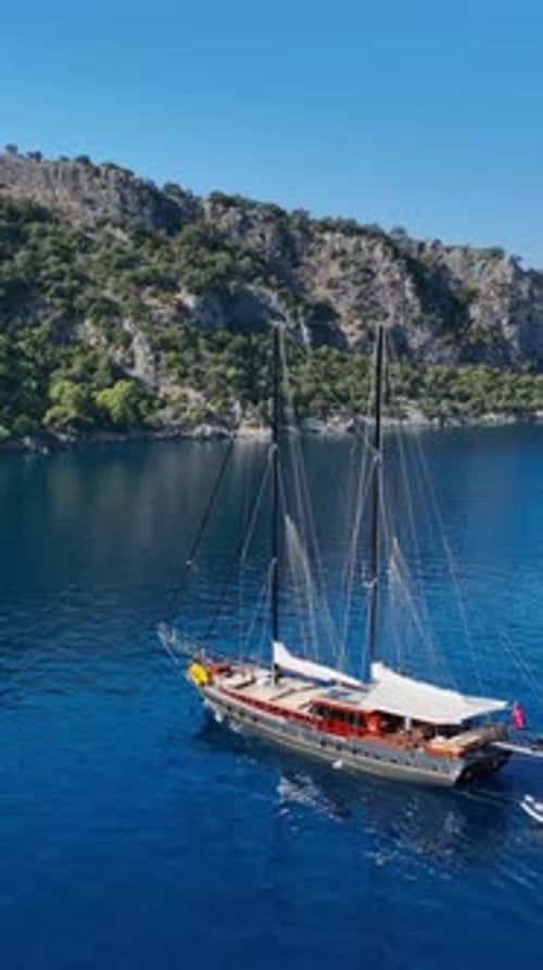 Aerial View of Sailboat Moored Near Lush Coastline
