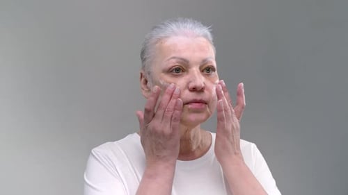 Senior Woman Applying Skincare Cream to Her Face