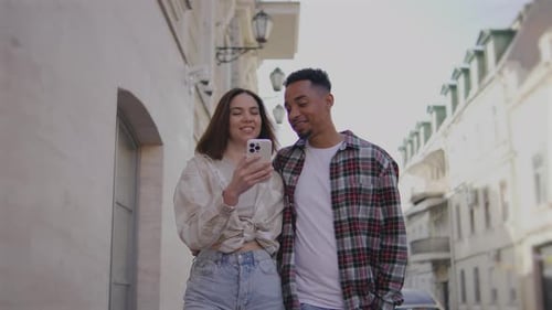 Multiethnic Couple in Love Walks Along the Narrow Streets of a European City The Guy and the Girl