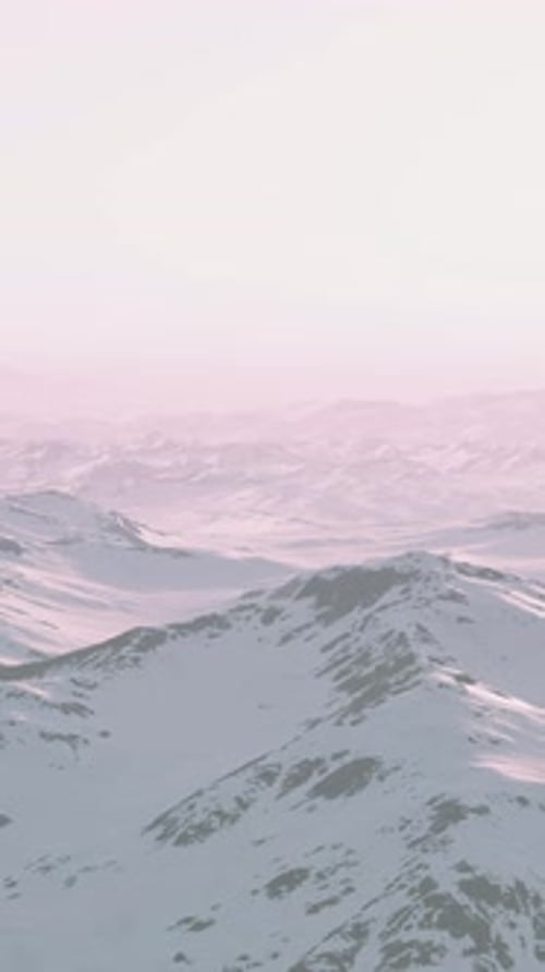 A Snowy Mountain Range at Sunset with a Beautiful Pink Sky