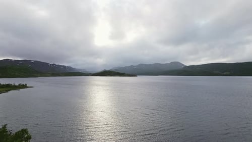 Drone Journey Over A Fjord With Mountains In View During Daylight