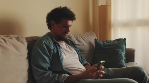 Man Using Smartphone While Sitting on Couch