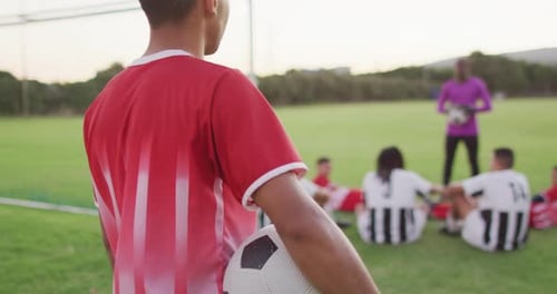 Video of biracial football player on field with ball