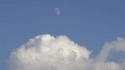 Clouds Moving Across Blue Sky With Moon