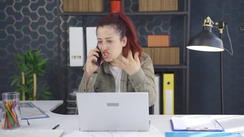 Upset Woman Talking on Phone in Office