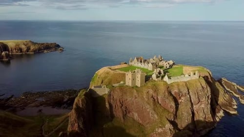 Une vue aérienne époustouflante du château de Dunnottar, une forteresse historique perchée au sommet d'une falaise spectaculaire