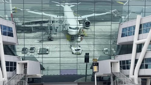 Modern Airplane Reflected on Glass Facade of Airport Terminal