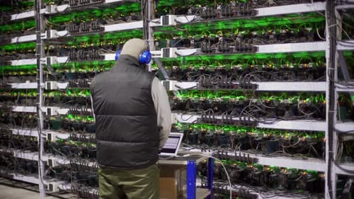 Data Center Diagnostics Technician Works and Types on Laptop Mining Equipment Service in Server Room