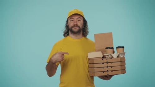 Delivery Man in Yellow Uniform Holding Pizza Boxes and Coffee Cup Holder Making a Call Gesture