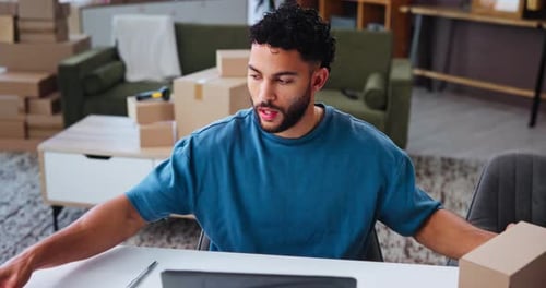 Young Man Managing Shipping Orders at Home Office
